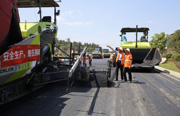 攤鋪機(jī)、壓路機(jī)等設(shè)備緊張有序運(yùn)行，高達(dá)170℃的瀝青混合料炙烤著公路人